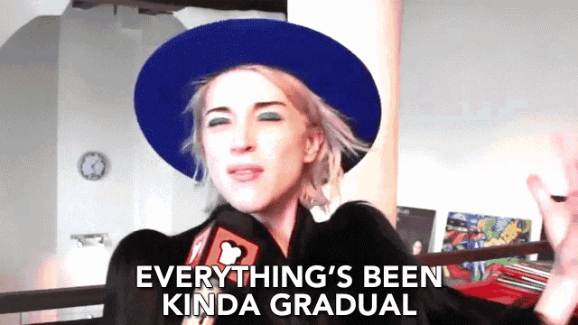 a woman wearing a blue hat and a black coat says everything 's been kinda gradual