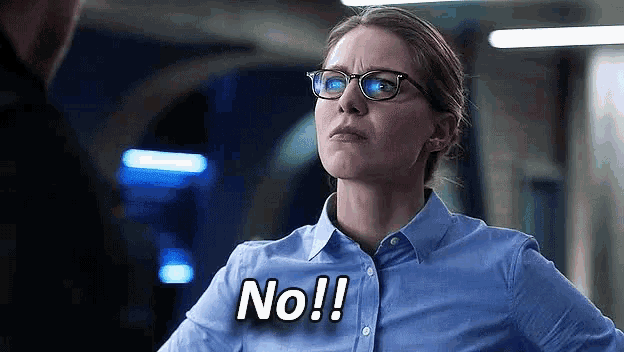 a woman wearing glasses and a blue shirt is making a funny face and saying no !