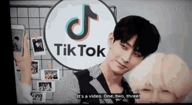 a man is standing in front of a tik tok sign