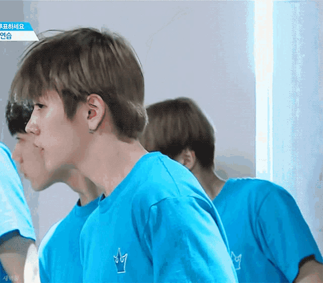 a boy wearing a blue shirt with a crown on the front
