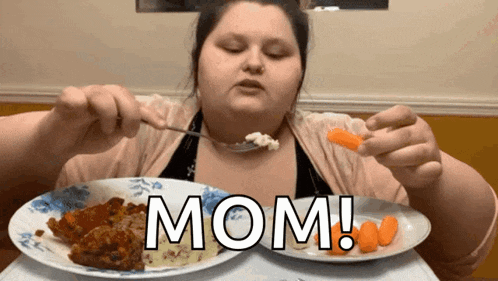 a woman is sitting at a table with two plates of food and the word mom written on the table