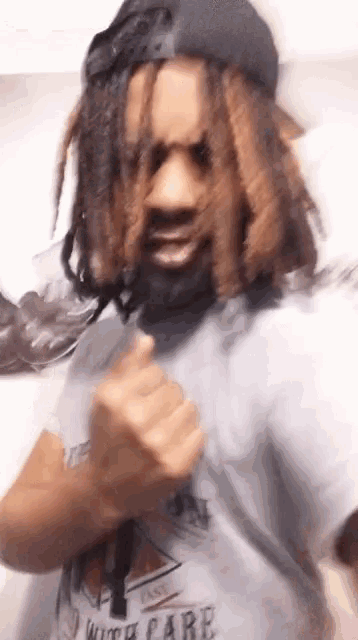 a man with dreadlocks wearing a t-shirt that says i with care