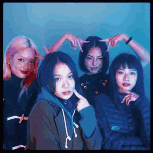 a group of young women are posing for a picture with their hands on their faces