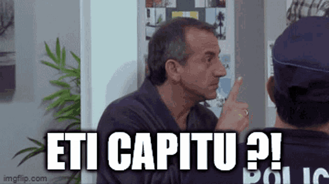 a man in a robe is pointing at another man and says " eti capitu " .