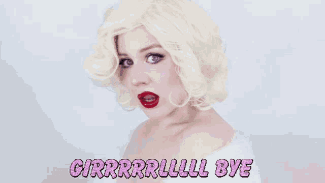 a woman wearing a blonde wig and red lipstick is saying bye