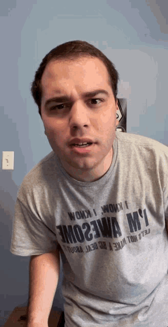 a man wearing a gray shirt that says wow i know