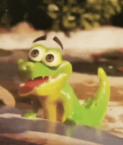 a green and yellow toy crocodile is sitting on a rock in a pool .