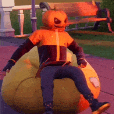 a person with a pumpkin head is sitting on a pumpkin bean bag chair .