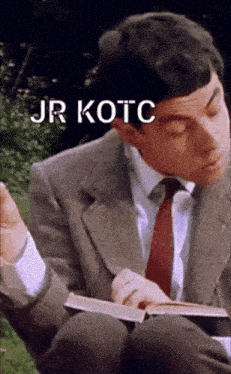 a man in a suit and tie is reading a book with the words jr kotc written above him