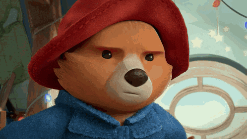 a teddy bear wearing a red hat and blue coat