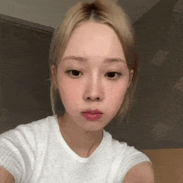 a young woman with blonde hair is taking a selfie with her phone .