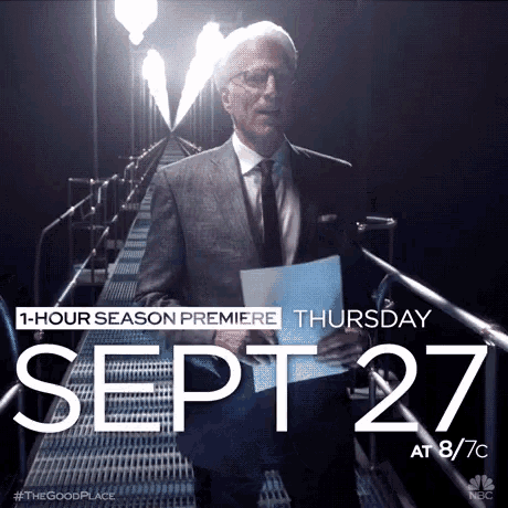 a man in a suit and tie holds a piece of paper in front of a sign that says september 27
