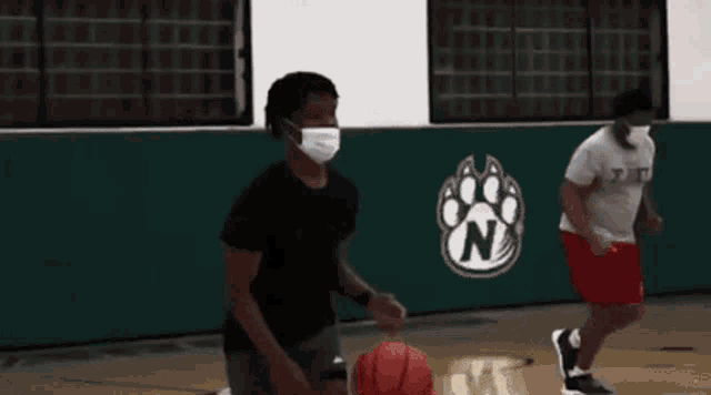 a person wearing a mask is dribbling a basketball on a court