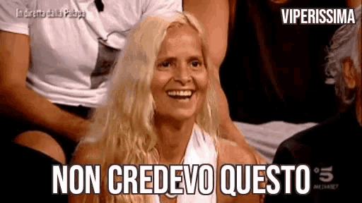 a woman with blonde hair is smiling with the words non credevo questo written below her