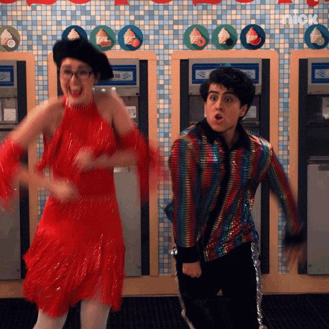 a woman in a red dress and a man in a colorful jacket are dancing in front of ice cream machines that say nick