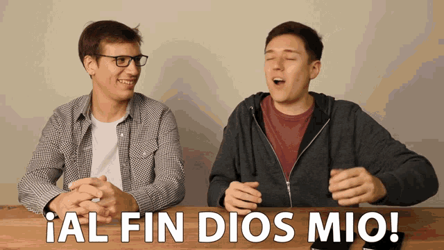 two men sitting at a table with the words " al fin dios mio " written on the bottom