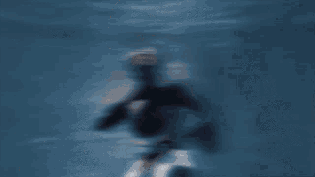 a scuba diver is swimming in the ocean with the words imagine behind her
