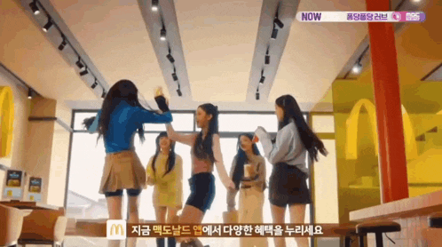 a group of girls are dancing in a mcdonalds restaurant