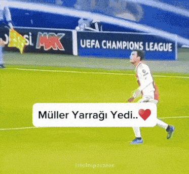 a soccer player on a field with a sign that says uefa champions league in the background