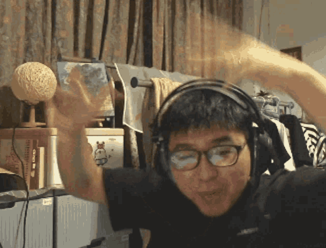 a man wearing headphones and glasses is waving