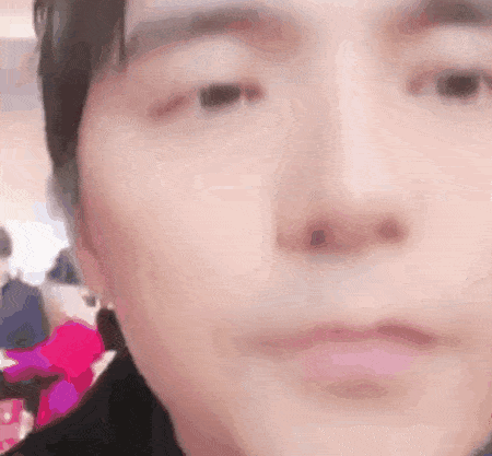 a close up of a person 's face with a blurry background and a pink lip .