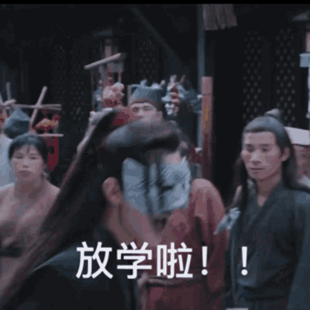 a man wearing a mask stands in a crowd of people with chinese writing behind him