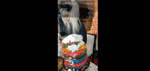 a woman is holding a cake that is covered in icing