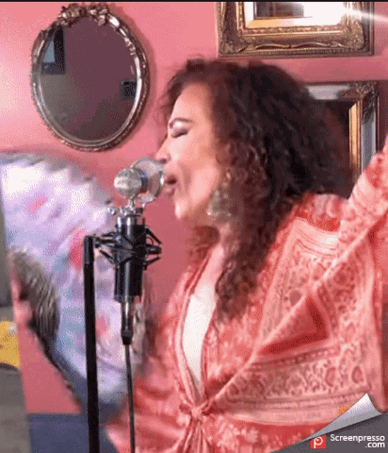 a woman singing into a microphone with screenpresso.com written on the bottom