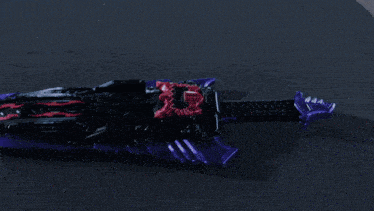 a robot is holding a purple sword with a red stripe on it