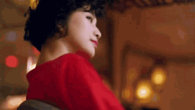 a woman in a red dress is looking up at something