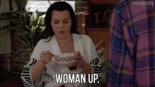 a woman is sitting at a table eating a bowl of soup and says woman up .