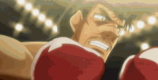 a man wearing red boxing gloves is fighting in a ring .
