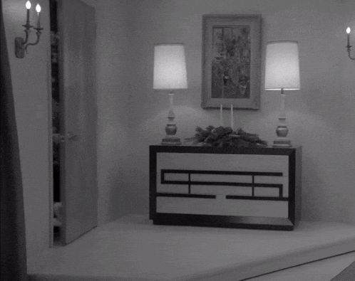 a black and white photo of a woman standing in a room
