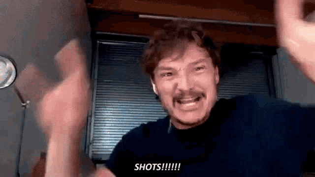 a man with a mustache is making a funny face and saying `` shots '' .