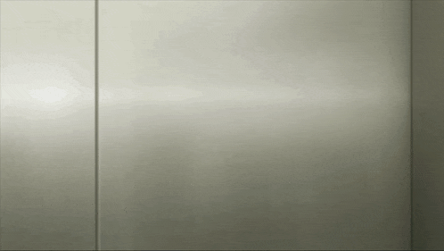 a close up of a stainless steel wall with a reflection