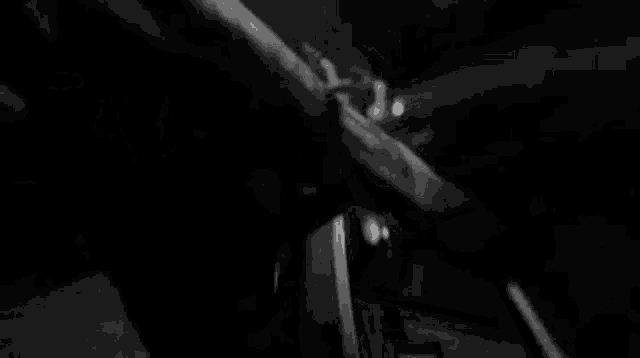 a black and white photo of a person dancing on a stage in a dark room .