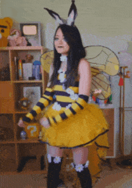 a woman in a bee costume is standing in front of a shelf
