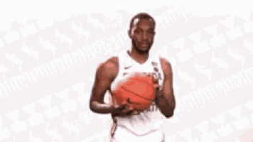 a man in a florida jersey is holding a basketball in his hand .