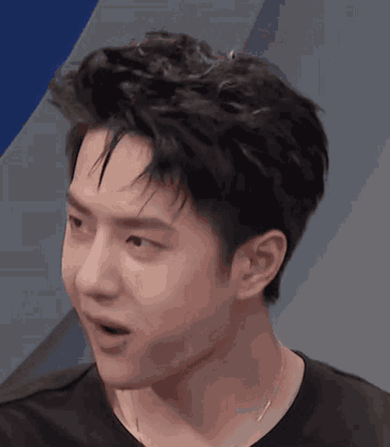 a close up of a young man 's face with his mouth open and a surprised look on his face .