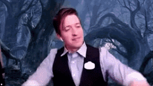 a man in a suit and vest is dancing in a forest .