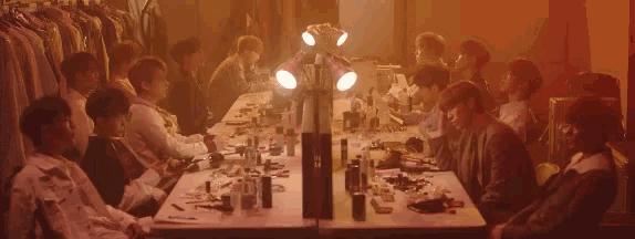 a group of people are sitting around a long table in a room .