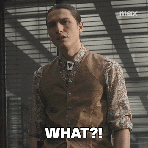 a man wearing a vest and a floral shirt says " what "