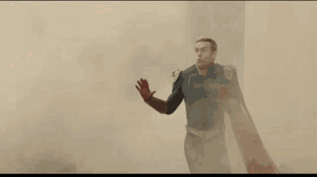 a man in a superhero costume is standing in a room with smoke coming out of it .