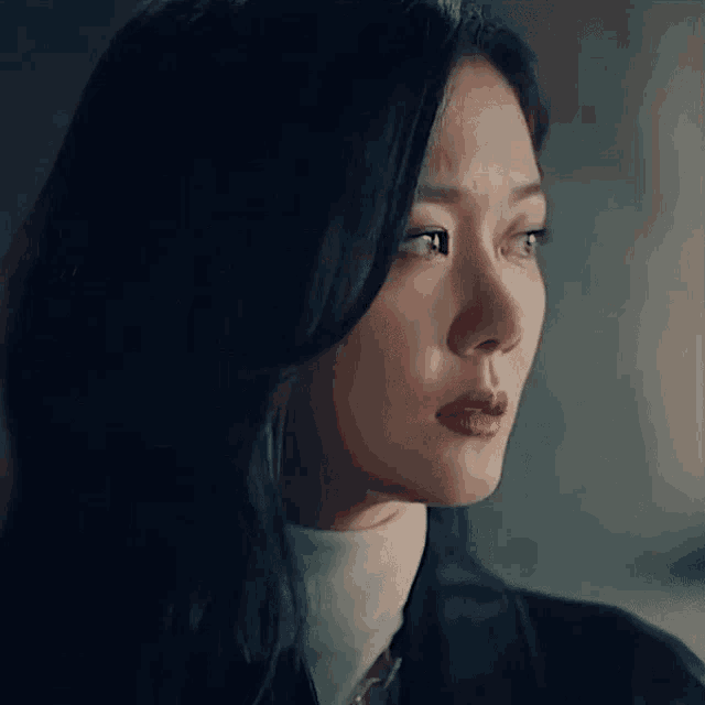 a close up of a woman 's face with a tear running down her cheek