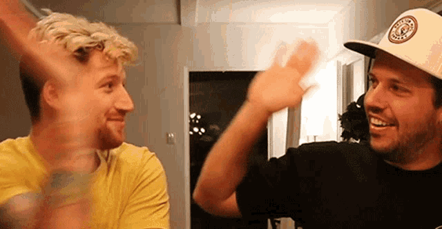two men in hats are giving each other a high five .