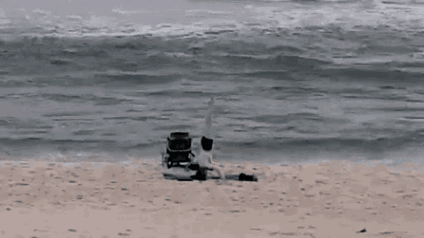 a person in a wheelchair is laying on the beach .