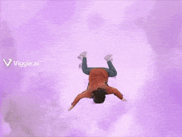 a person is doing a handstand in the air with purple clouds behind them .