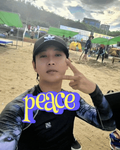 a man taking a selfie with the word peace on his shirt