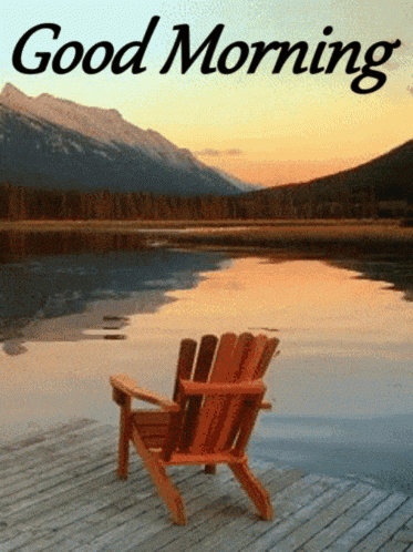a wooden chair sits on a dock near a lake with mountains in the background and the words good morning