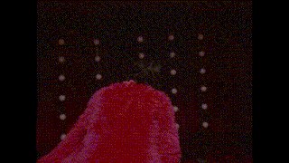 a woman in a pink fur coat is holding a microphone in front of a lamp .
